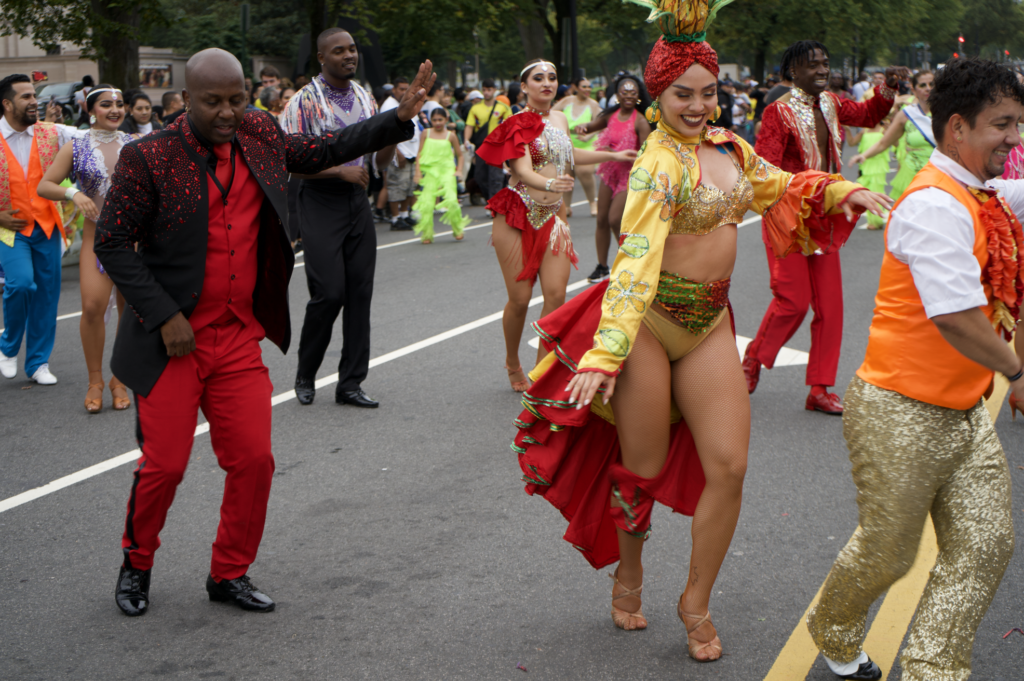 Colorful carnival dancers parading down street