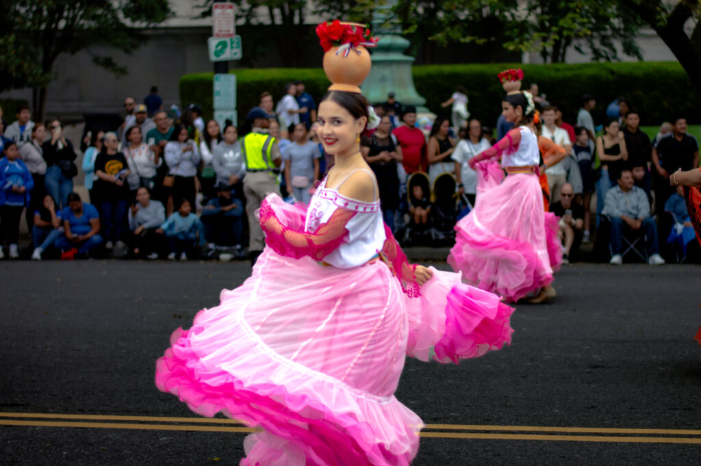 Parade dancer in pink dress balancing clay pot