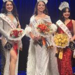 Three crowned beauty queens holding bouquets on stage